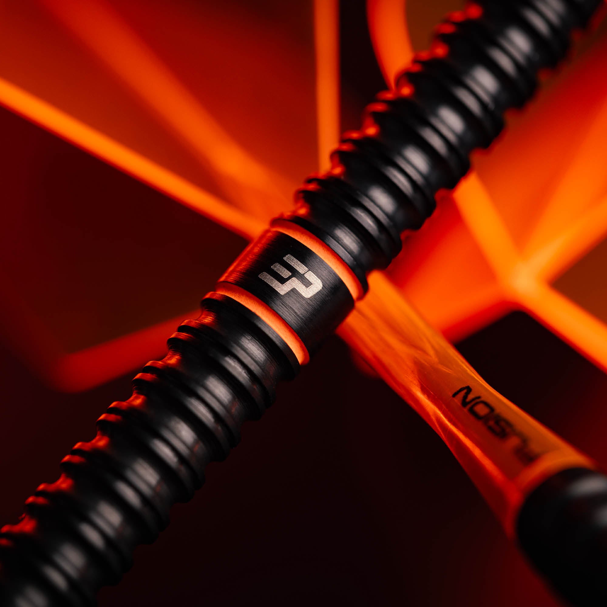Close up detail shot of Winmau Emma Paton dart, in black and orange.